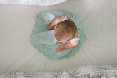 坐在白色纺织品上的婴儿